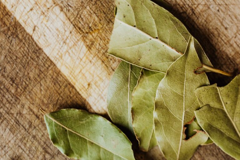 Dried bay leaves on a wooden board for bay leaf spells.