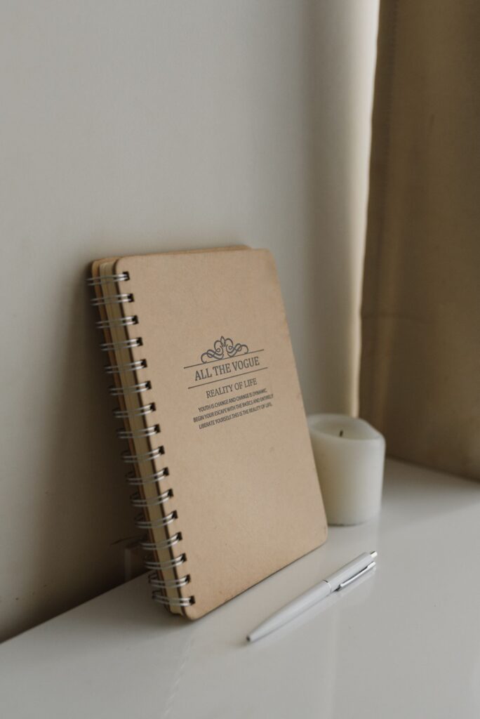 Notebook, pen, and candle for writing a spell.