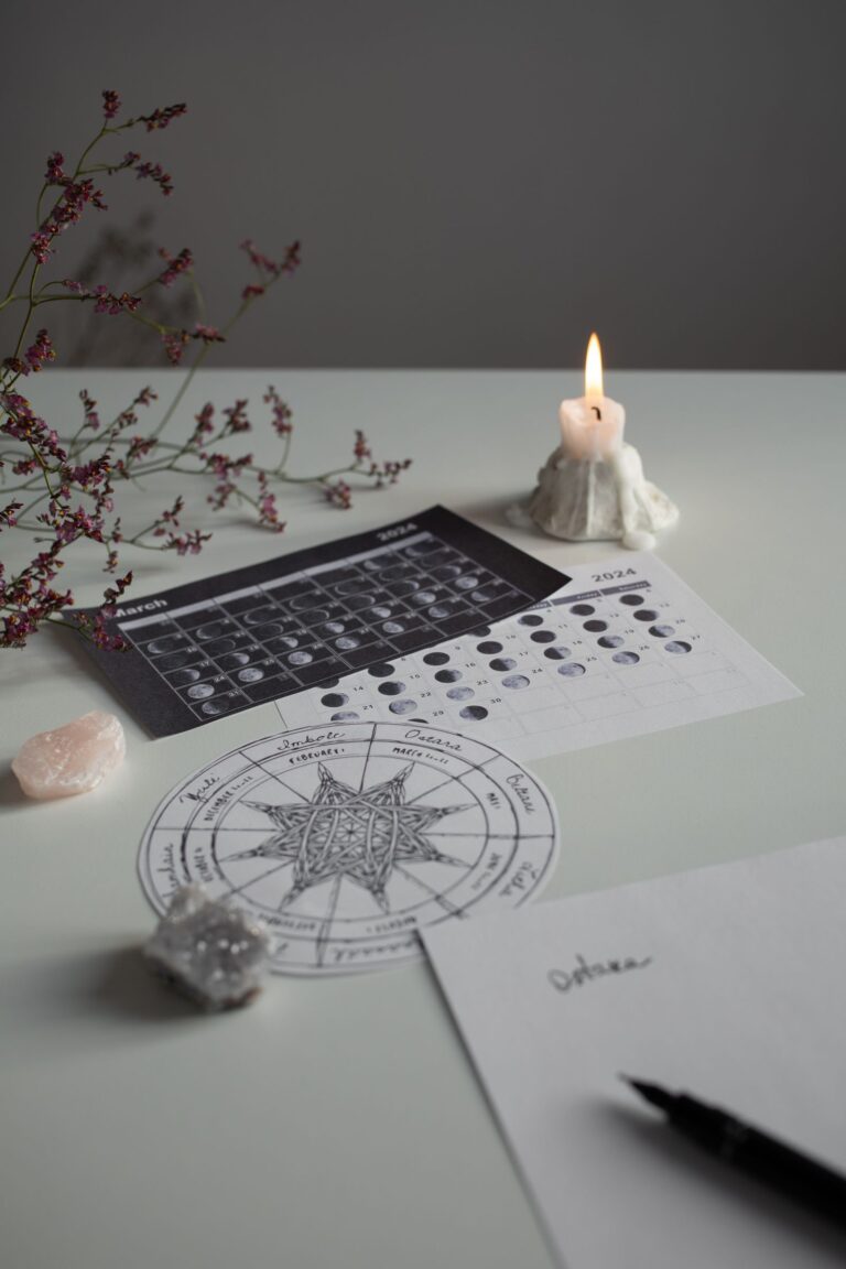 Moon phase cards, candle, and crystals arranged for a new moon ritual.