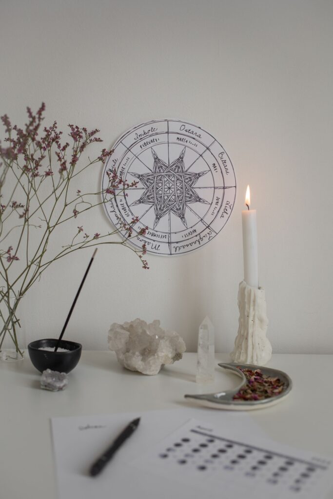 A small witchcraft practice setup with candles, cards, and ritual objects.
