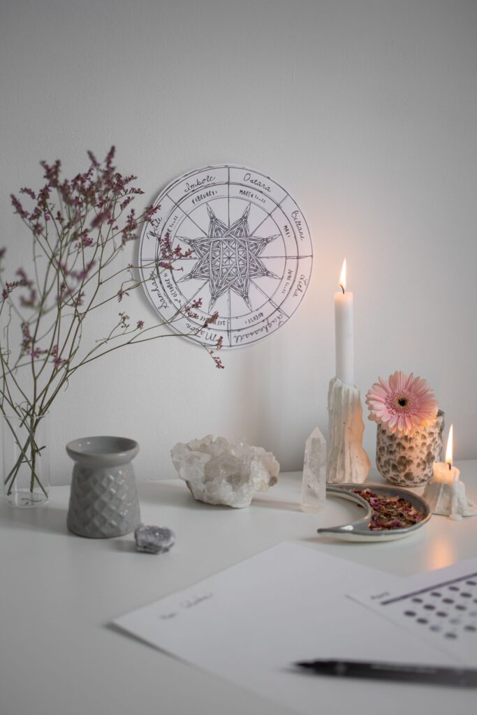 A compact altar-style setup with candles, cards, crystals, and ritual tools.