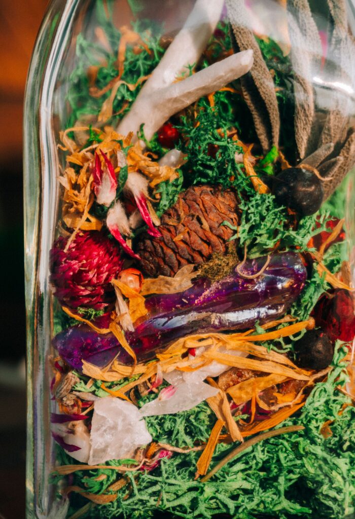 Glass jar filled with dried botanicals for spell jar basics.