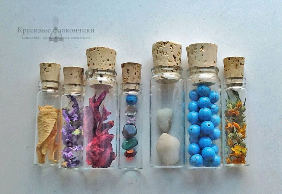 Glass vials filled with herbs, flower petals, and colored stones for spellwork.